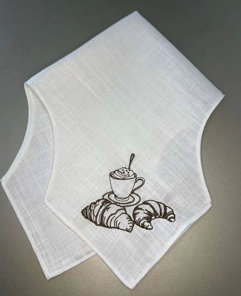 Panera de lino con una taza de café y croissants bordados